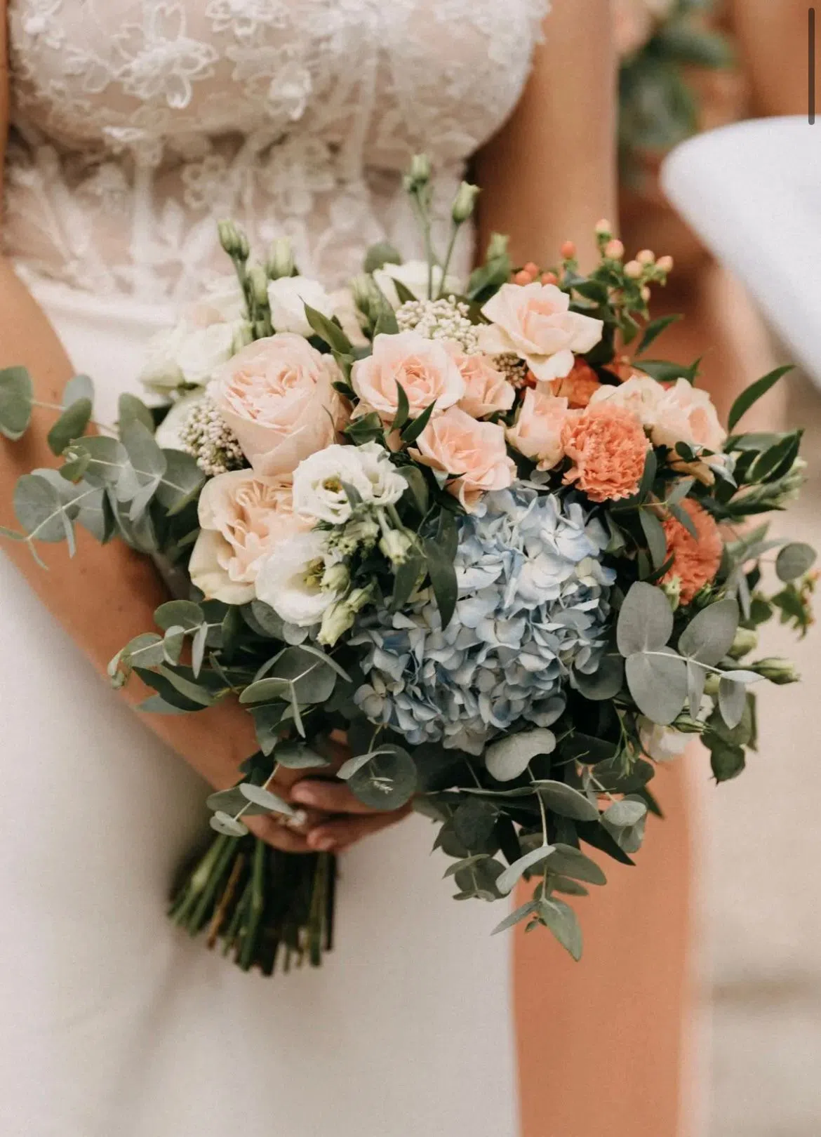 Bouquet LIPPOLIS con ortensie celesti, rose peach e garofani arancio — composizione estiva
